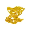 A close-up of a golden, translucent cannabis Diamond Concentrates shatter piece with irregular edges and bubble-like holes scattered throughout.