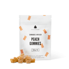 A close-up image of the BuudaBomb Peach Gummies, with the white packaging featuring small peach-colored gummy bears, and a pile of peach-flavored gummies in front