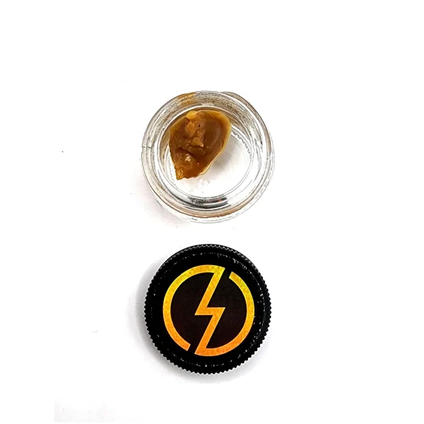 Overhead view of an open jar of High Voltage Extracts Live Resin with a black lid displaying a yellow lightning bolt logo. The live resin is visible inside the glass jar