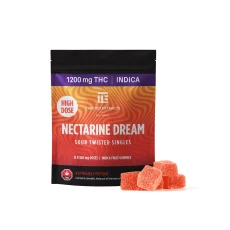 A package of Twisted Extracts High Dose Nectarine Dream Sour Twisted Singles, displaying a vibrant orange gradient swirl design, 1200mg THC, Indica, and orange gummy cubes in front of the package