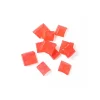 Cherry hard candy pieces scattered on a white background with a rich red color.