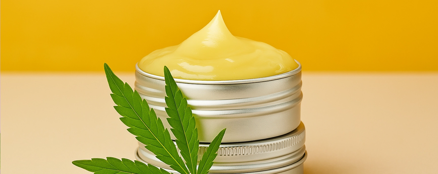 CBD cream jar on warm yellow background with cannabis leaf