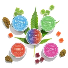 Boost 150mg THC Gummies with a cannabis leaf, scattered gummies and cannabis buds on white background